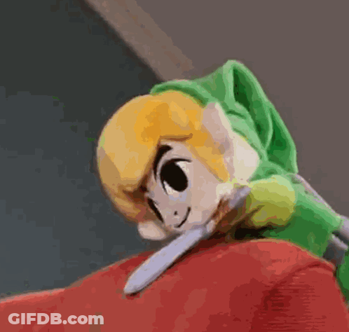 A Stuffed Zelda Link Is Laying On Top Of A Red Couch . GIF
