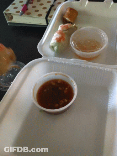 A Styrofoam Container Filled With Food And Dipping Sauces GIF