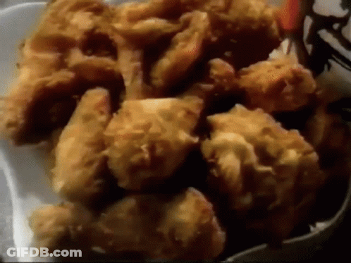 A Styrofoam Container Filled With Fried Chicken Pieces GIF