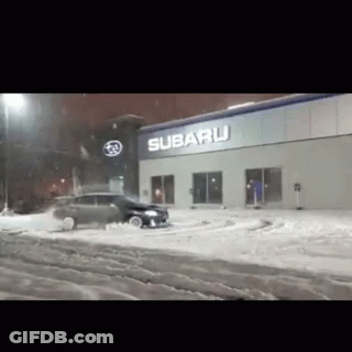 A Subaru Store With A Car In The Snow GIF
