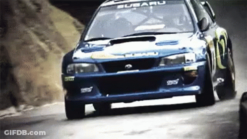 A Subaru Wrx Sti Is Driving Down A Hill . GIF