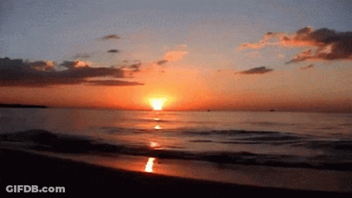 A Sunset Over A Body Of Water With The Sun Shining Brightly GIF
