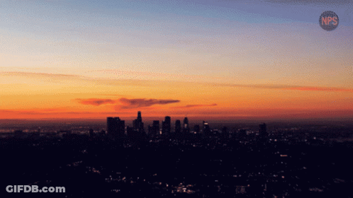 A Sunset Over A City With The Letters Nps On The Bottom Right GIF