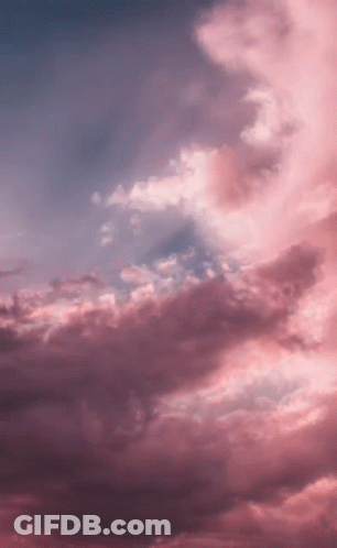 A Sunset With Pink Clouds In A Blue Sky . GIF