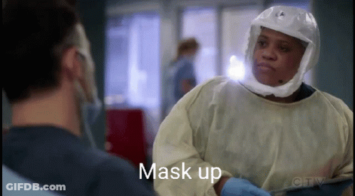 A Surgeon Wearing A Helmet And Gloves Is Talking To Another Surgeon . GIF