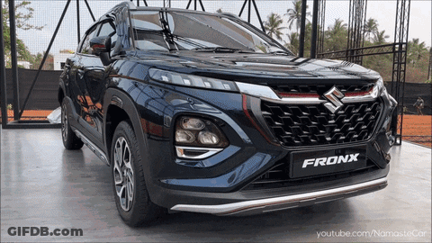A Suzuki Fronx Is Parked In Front Of A Fence GIF