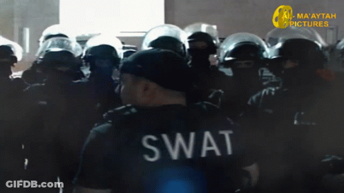 A Swat Officer Stands In Front Of A Crowd Of Police GIF