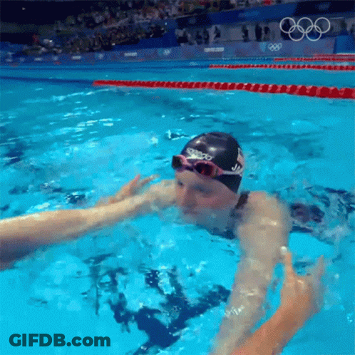 A Swimmer Wearing A Speedo Swim Cap And Goggles GIF