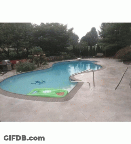 A Swimming Pool With A Green Raft In The Middle Of It GIF