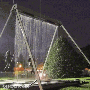 A Swing Set With Water Coming Out Of It GIF