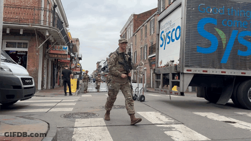 A Sysco Truck Is Driving Down A Busy Street GIF