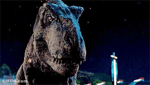 A T-Rex Dinosaur Is Standing In The Dark With Its Mouth Open . GIF
