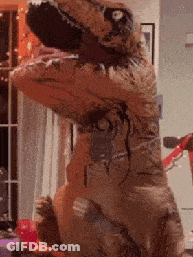 A T-Rex With Its Mouth Open Is Standing In A Living Room GIF