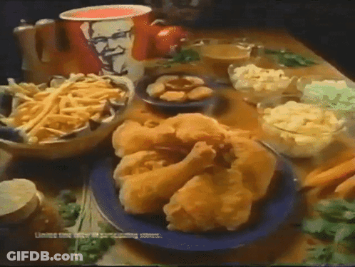 A Table Topped With Fried Chicken French Fries And Mashed Potatoes With A Kfc Cup In The Background GIF