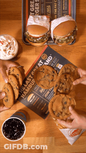 A Table Topped With Hamburgers And Cookies With A Sign That Says The Last Great Hamburger GIF