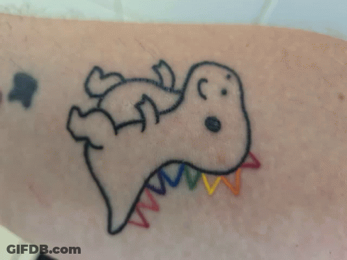 A Tattoo Of A Dinosaur With A Rainbow Tail On A Person 'S Arm GIF