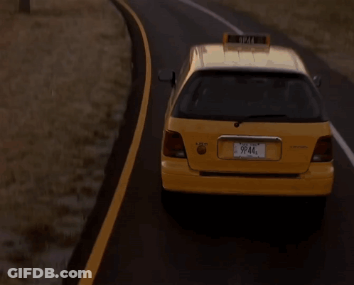 A Taxi Is Driving Down A Road With A City In The Background GIF
