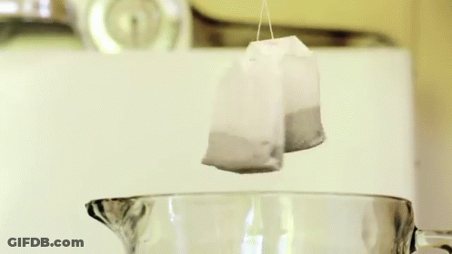 A Tea Bag In A Measuring Cup With A Label That Says Raspberry GIF