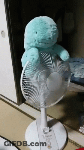 A Teal Stuffed Animal Is Sitting On Top Of A White Fan GIF