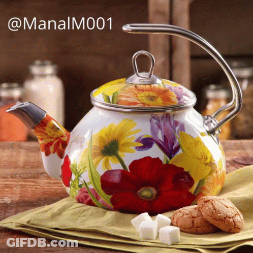 A Teapot With Flowers Painted On It Sits On A Table GIF