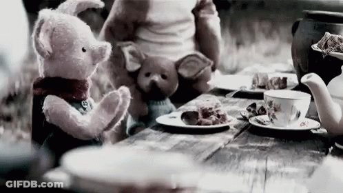 A Teddy Bear And A Pig Are Sitting At A Table With Plates Of Food . GIF
