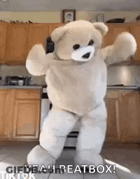 A Teddy Bear Is Dancing In A Kitchen In A Costume . GIF