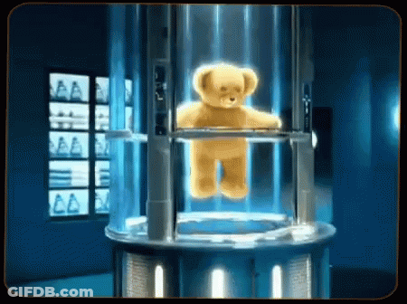 A Teddy Bear Is Floating In A Clear Container GIF