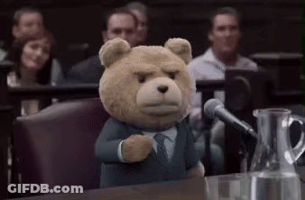 A Teddy Bear Is Giving A Speech In Front Of A Microphone In A Courtroom . GIF
