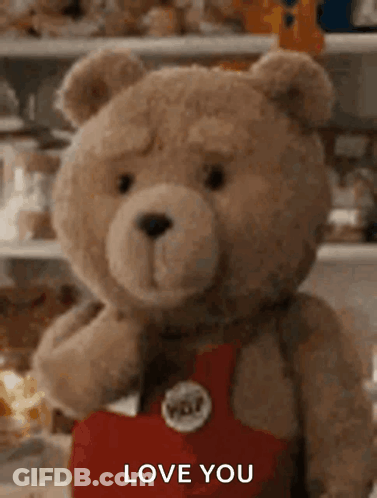 A Teddy Bear Is Holding A Heart And Saying `` I Love You '' . GIF