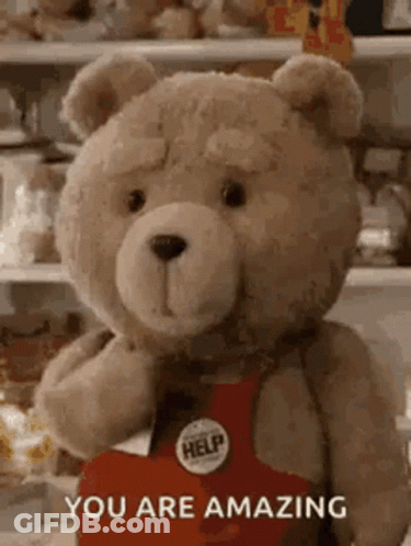 A Teddy Bear Is Holding A Heart With The Words `` You Are Amazing '' Written On It . GIF