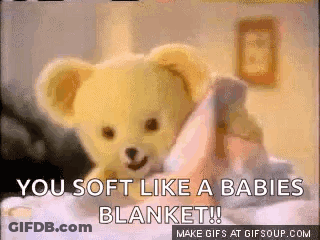 A Teddy Bear Is Laying On A Bed With The Words You Soft Like A Babies Blanket GIF