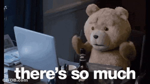 A Teddy Bear Is Sitting In Front Of A Laptop With The Words " There 'S So Much " Written Below It GIF