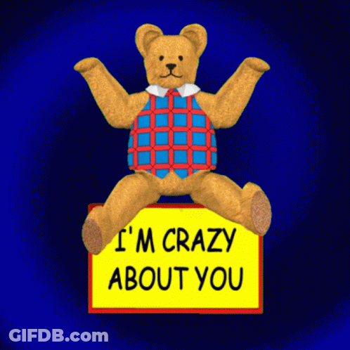 A Teddy Bear Is Sitting On A Yellow Sign That Says I 'M Crazy About You GIF