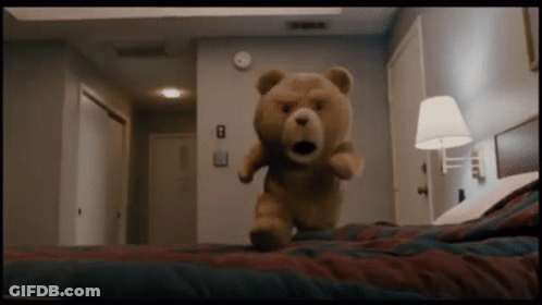 A Teddy Bear Is Standing On A Bed With The Number 8 On The Wall GIF