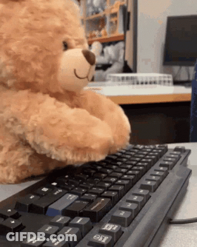 A Teddy Bear Is Typing On A Black Keyboard With The Esc Key Visible GIF