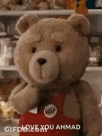 A Teddy Bear Is Wearing A Red Apron And Holding A Heart . GIF