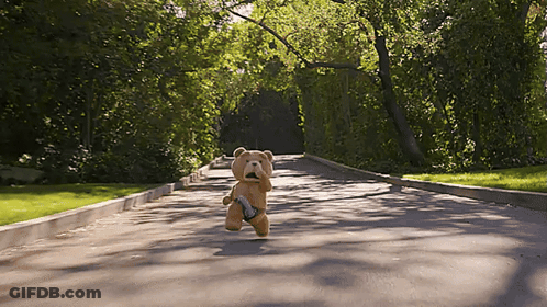 A Teddy Bear Running Down A Road With A Gun GIF