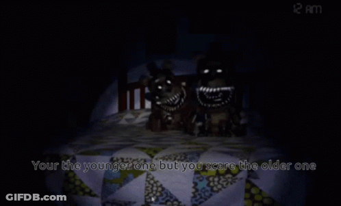 A Teddy Bear Sits In A Bed With The Words " Your The Younger One But You Scare The Older One " GIF