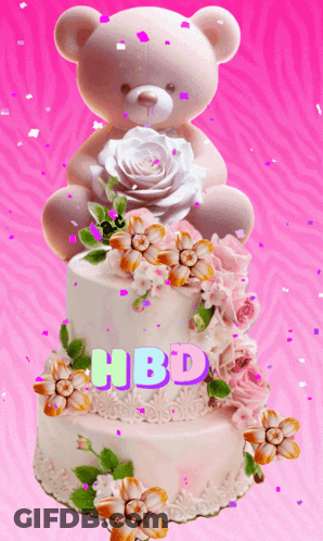 A Teddy Bear Sits On Top Of A Birthday Cake GIF