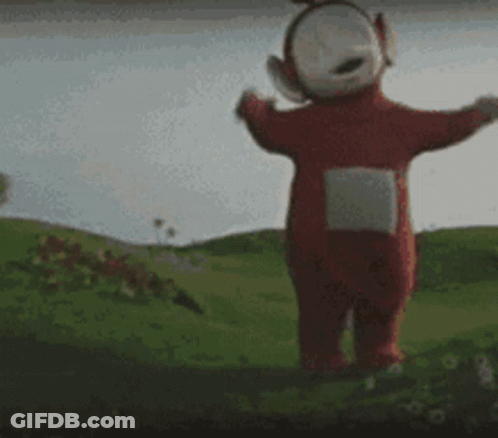A Teletubbies Character Is Standing In A Grassy Field With His Arms Outstretched GIF