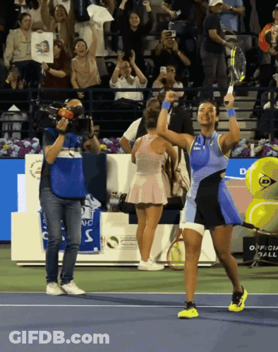 A Tennis Player Holds Her Racket In The Air In Front Of A Crowd GIF