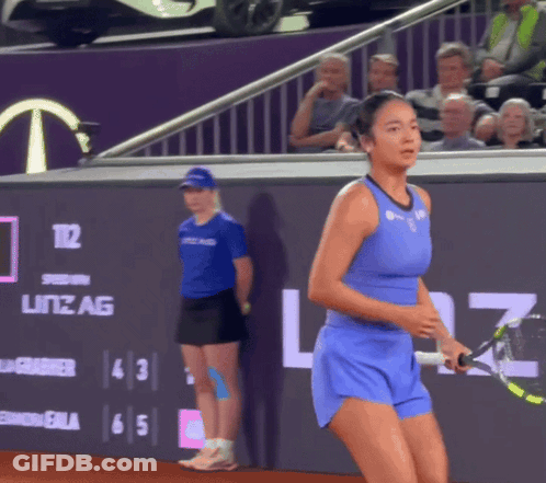 A Tennis Player In A Blue Outfit Is Holding A Tennis Racquet In Front Of A Sign That Says Litz Ag GIF
