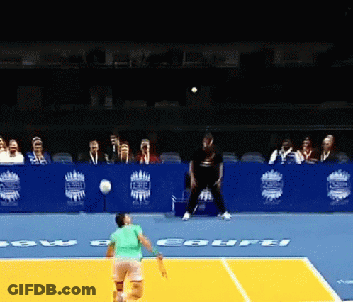 A Tennis Player In A Green Shirt Is About To Serve A Ball On A Court That Has The Word Courts On It GIF