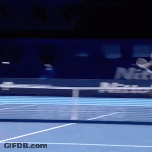 A Tennis Player Is Hitting A Ball On A Blue Court GIF
