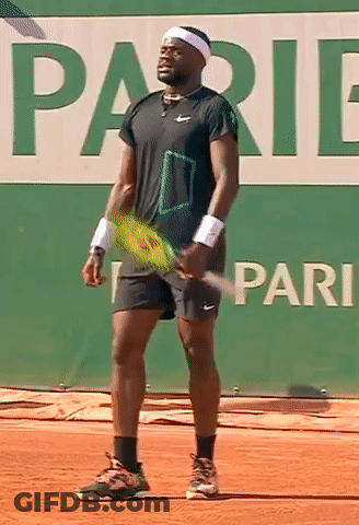 A Tennis Player Is Holding A Tennis Racquet In Front Of A Sign That Says Pari GIF