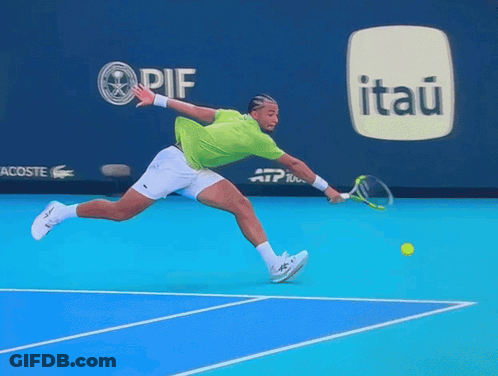 A Tennis Player Is Jumping In The Air While Holding A Racket In Front Of An Advertisement For Itaú GIF