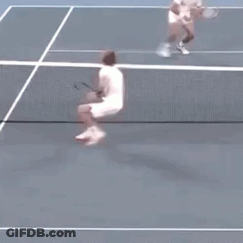 A Tennis Player Is Jumping In The Air While Holding A Tennis Racquet . GIF