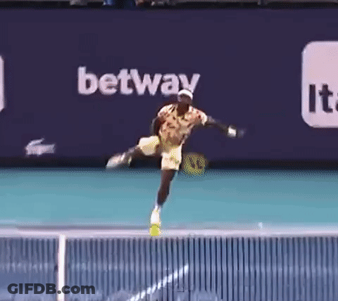 A Tennis Player Is Jumping In The Air While Holding A Tennis Racquet . GIF