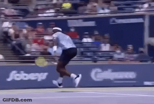 A Tennis Player Is Jumping In The Air While Holding A Tennis Racquet . GIF