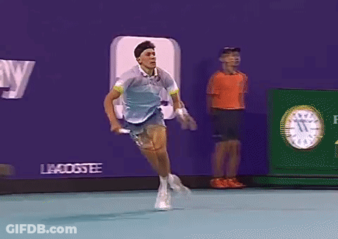 A Tennis Player Is Running On A Court In Front Of An Advertisement For Betty GIF